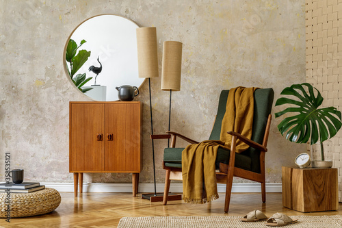 Modern retro composition of living room interior with design armchair, pouf, tea pot on the tray, plant, plaid, carpet, decoration and elegant presonal accessories in wabi sabi concept. photo