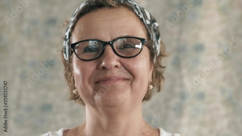 An happy old woman is smiling to camera. Close up shot of beauty elderly senior woman laughing