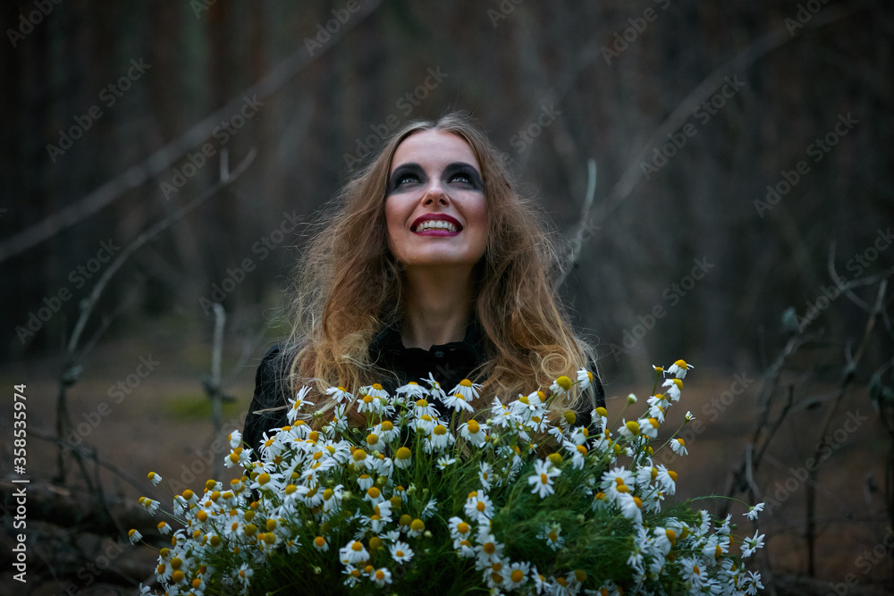 witch girl with a bouquet of daisies in a dark pine forest witch girl with a bouquet of daisies in a dark pine forest