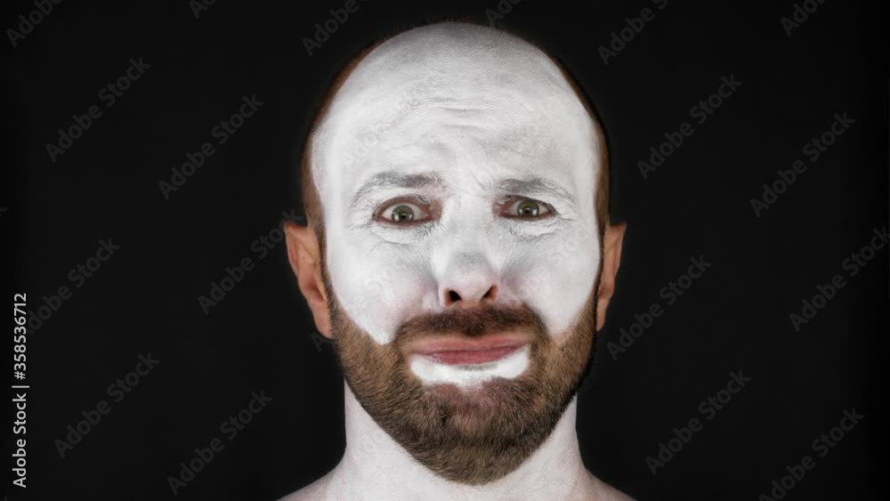 A mime man in a white mask depicts emotions. Man on a black background. High quality 4k footage A mime man in a white mask depicts emotions. Man on a black background. High quality 4k footage