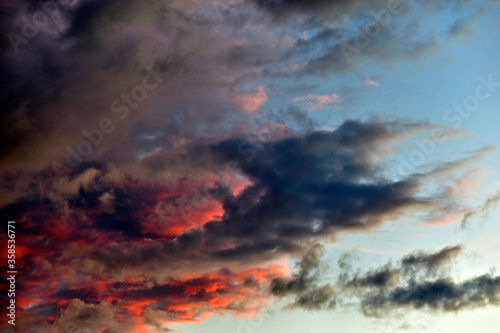 Evening sky and clouds tinged with multicolored rays of the sun