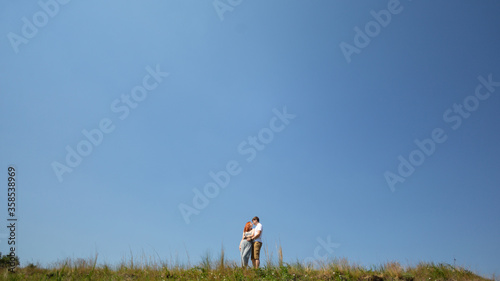 Hugs on the background of clear sky. The concept of a happy relationship. A happy family.