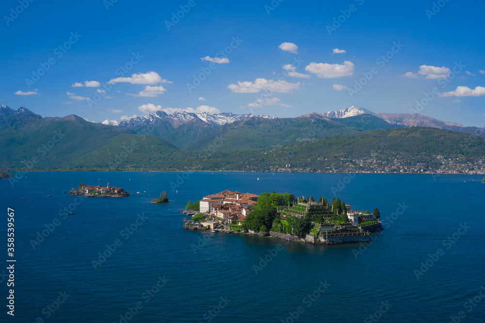 Isola Bella is located on Lake Maggiore in Italy. Gorgeous garden Borromee in the background the alps in the snow, clouds in the blue sky