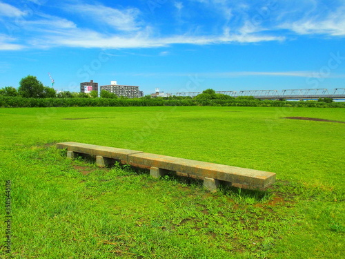 石のベンチのある初夏の江戸川河川敷風景