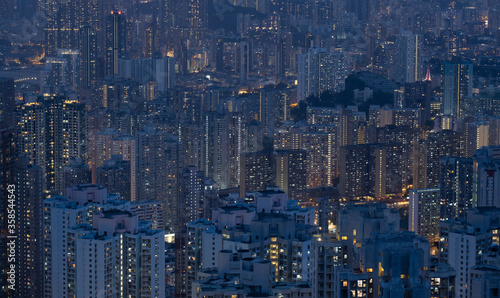 Crowded city with lights turning on and off at night. Hong Kong city apartment buildings at night. 