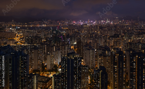 Crowded city with lights turning on and off at night. Hong Kong city apartment buildings at night. 