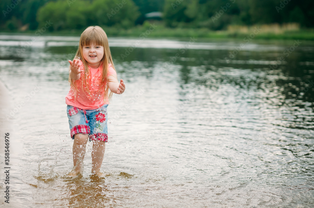 Portrait of a cheerful girl on the beach in summer playing in the water Portrait of a cheerful girl on the beach in summer playing in the water