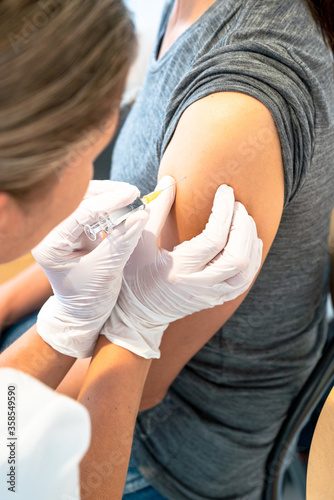 Fotografija vertical view of female doctor vaccinating a female patient
