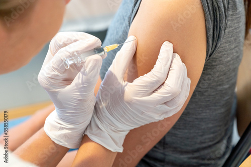 horizontal view of female doctor vaccinating a female patient