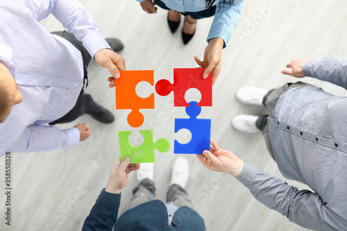 Εκτύπωση καμβά Group businees people hold color element puzzle top view background closeup