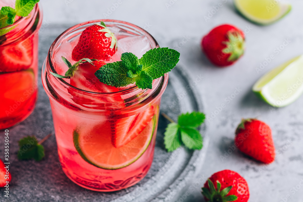 Strawberry lime lemonade with fresh mint and ice in glass jar. Strawberry lime lemonade with fresh mint and ice in glass jar.