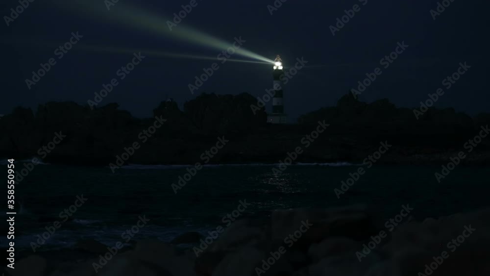 Very powerful Creach lighthouse illuminated in evening, Ushant island, France