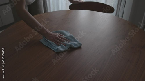 Woman cleaning the kitchen table with a cloth photo