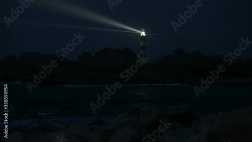 Very powerful Creach lighthouse illuminated in evening, Ushant island, France
