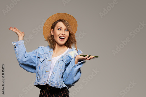 фотографія Joyful young girl in a hat with a mobile phone in her hands