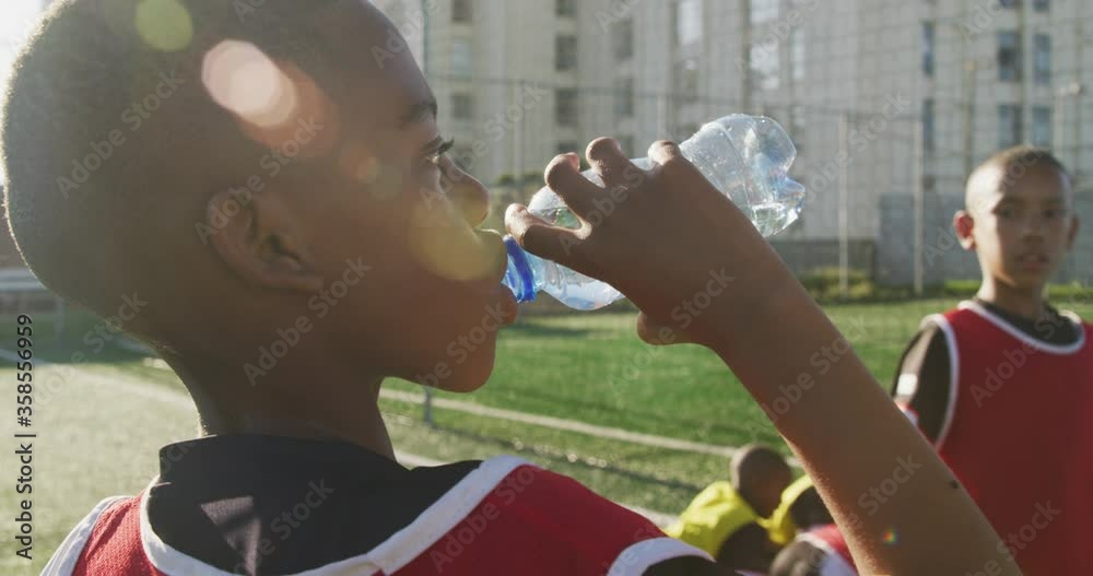 Soccer kids drinking water in a sunny day