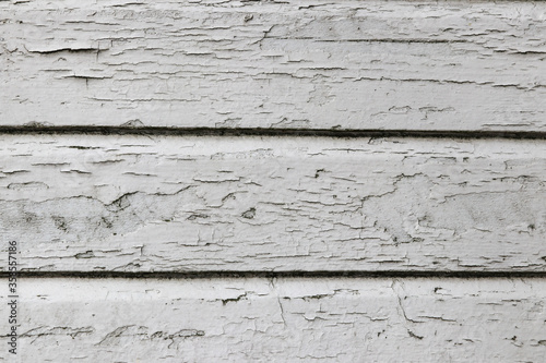 A white wooden wall with cracked paint