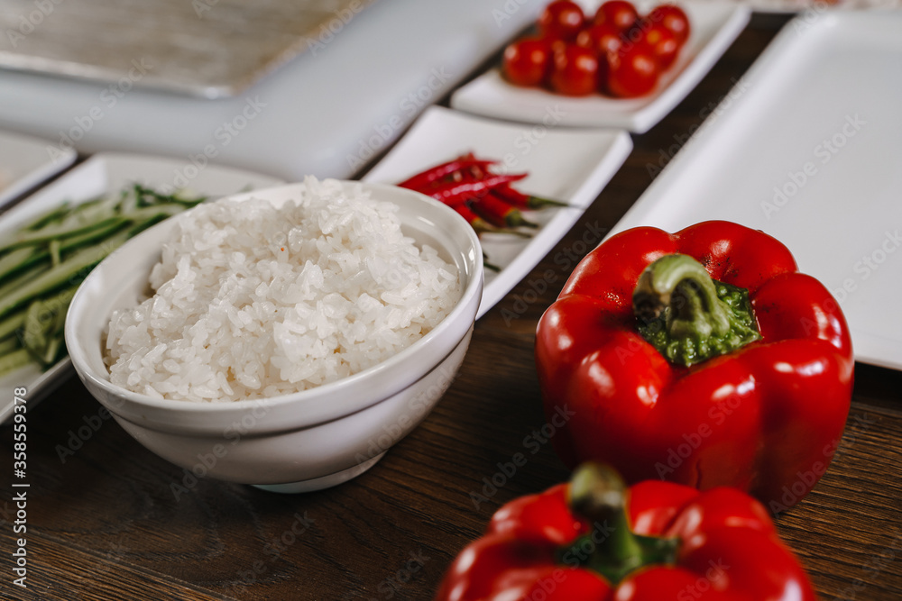 Boiled rice in a bowl surrounded by vegetables .Food preparation Boiled rice in a bowl surrounded by vegetables .Food preparation