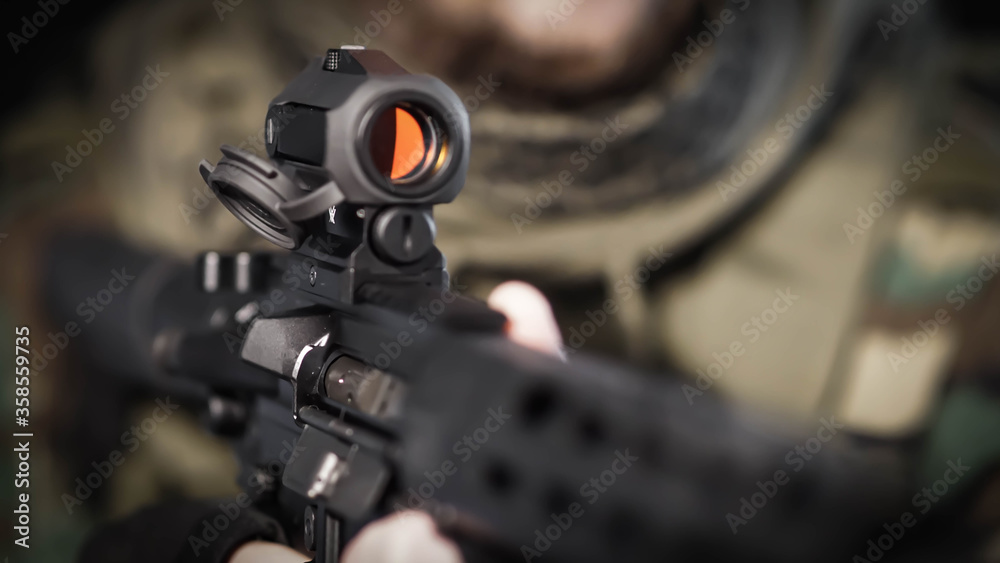 Abstract closeup of security contractor holding an AR15 Rifle with focus on the optic Abstract closeup of security contractor holding an AR15 Rifle with focus on the optic