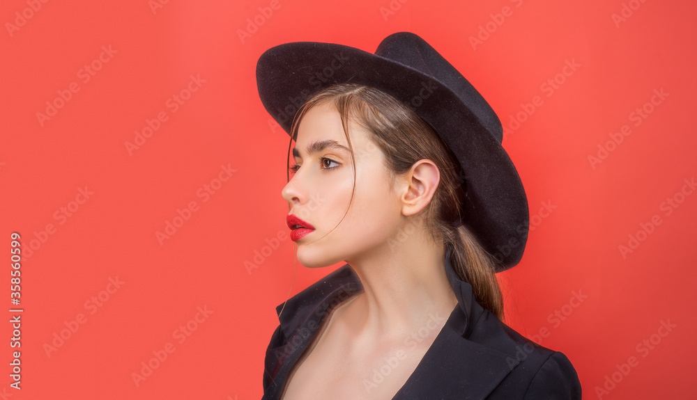 Young Beautiful Woman in black hat. Young woman studio portrait on red. Young Beautiful Woman in black hat. Young woman studio portrait on red.