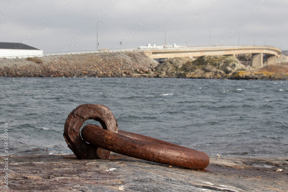 A rusty iron mooring by the sea. It is drilled into the rock A rusty iron mooring by the sea. It is drilled into the rock