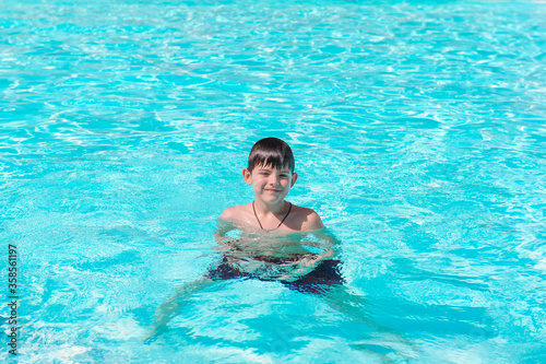 Activities on the pool, children swimming and playing in water, happiness and summertime. Young Boy Fun in the Swimming Pool with Goggles. Summer Vacation Fun.
