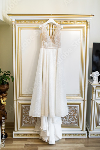 Wedding dress hanging on the door.