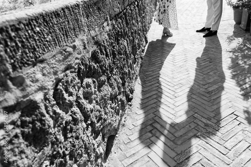 Shadows of a wedding couple on the cobblestones.