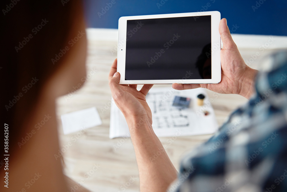 Detail of man holding a digital tablet at house