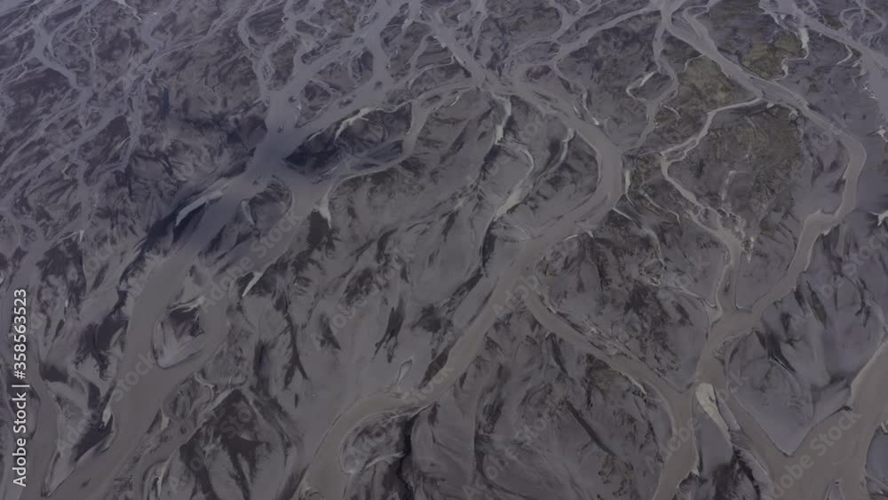 Aerial shot of river delta amidst rock formations on sunny day, drone flying forward over natural pattern - Southwestern Iceland, Iceland Aerial shot of river delta amidst rock formations on sunny day, drone flying forward over natural pattern - Southwestern Iceland, Iceland