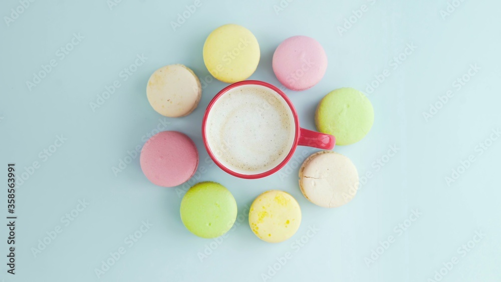 Macaroons or macaron on pastel blue surface with espresso in white cup. Macaroons or macaron on pastel blue surface with espresso in white cup.