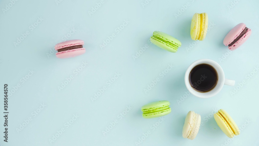 Macaroons or macaron on pastel blue surface with espresso in white cup. Macaroons or macaron on pastel blue surface with espresso in white cup.
