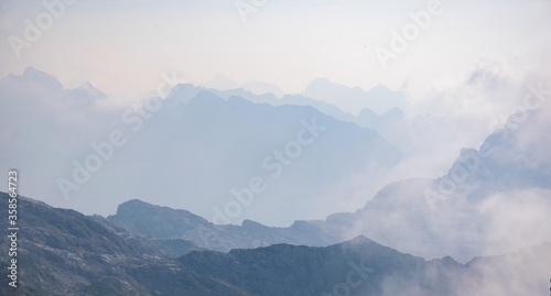 Beautiful background with blue ridge in hazy mountains. Julian Alps