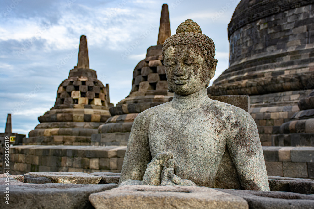 Fototapeta premium Buddha in a temple with stupas 
