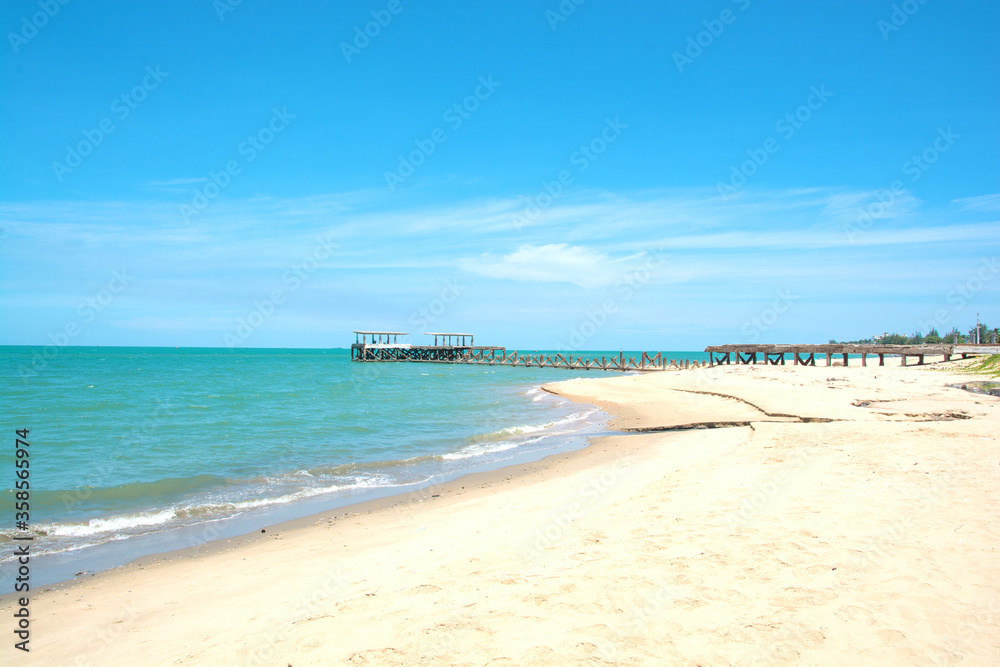 Old pier or a bridge is broken on the beach into the sea with blue sky at Hua Hin District, Thailand
