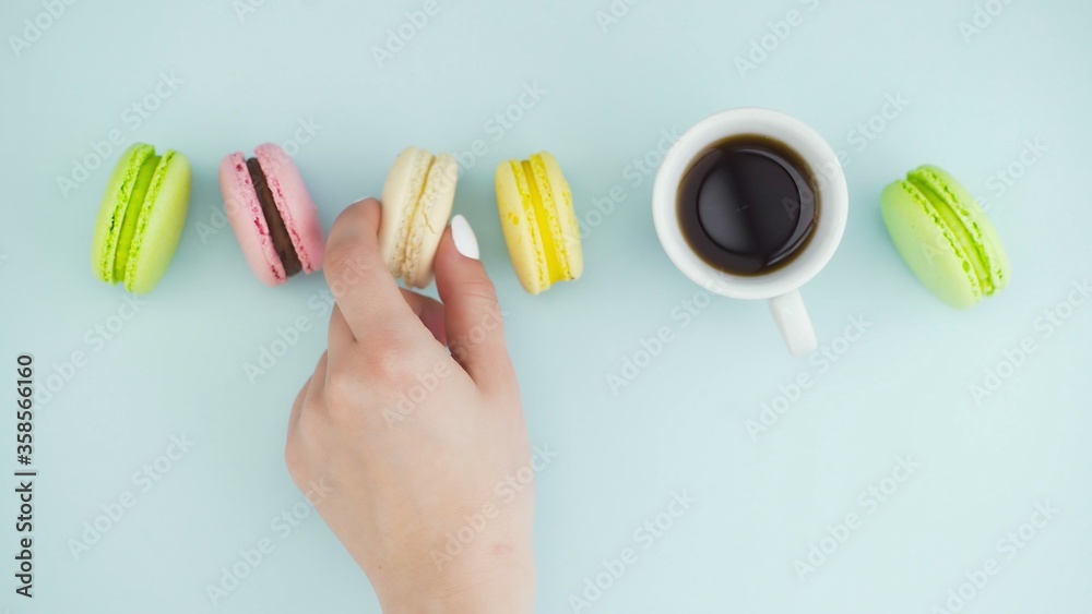 Macaroons or macaron on pastel blue surface with espresso in white cup. Macaroons or macaron on pastel blue surface with espresso in white cup.