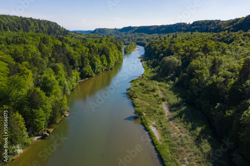 Bird view of Isar river comming from the Alps throgh a valley full of forest in spring summer time. Aerial photo of german river south of Munich.