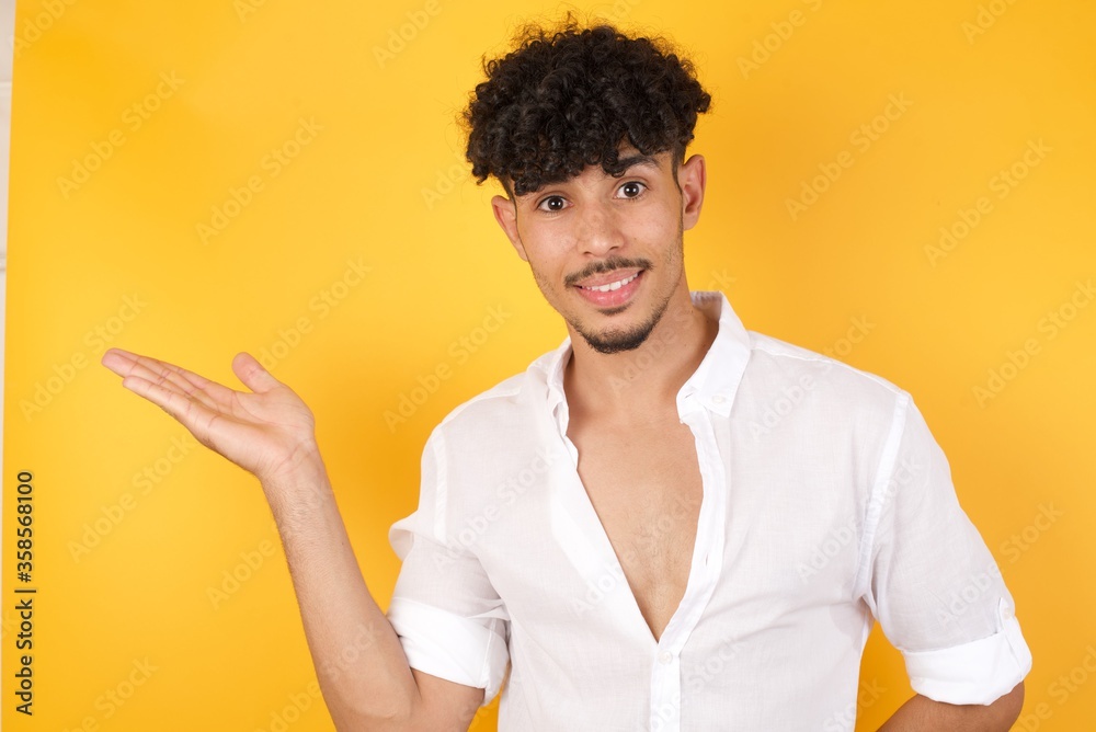 Positive glad male says: wow how exciting it is, has amazed expression, shows something on blank space with open hand over isolated gray background. Advertisement concept. Positive glad male says: wow how exciting it is, has amazed expression, shows something on blank space with open hand over isolated gray background. Advertisement concept.