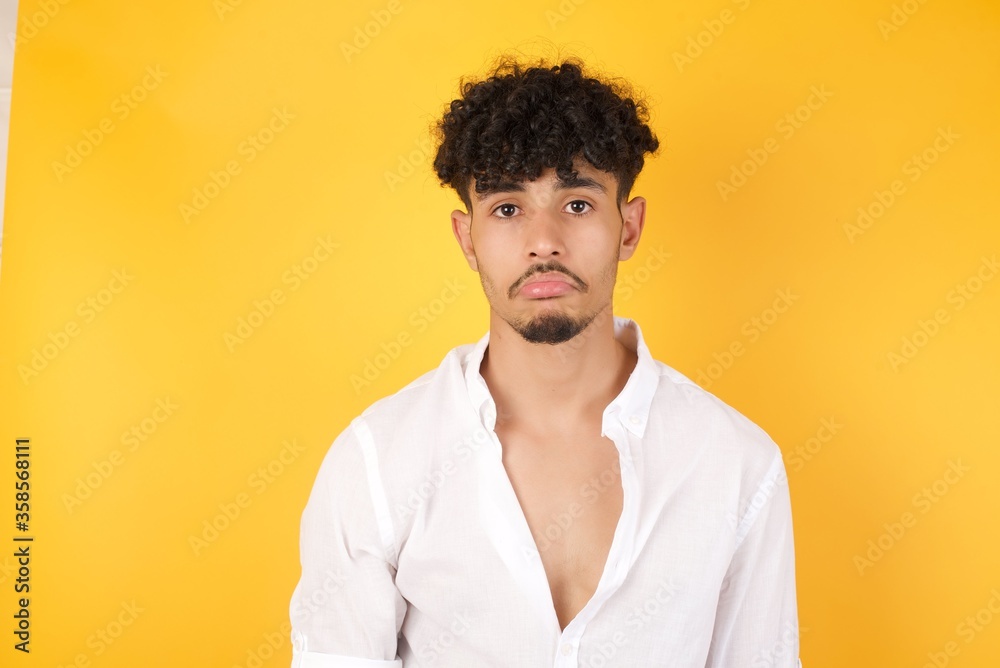 Gloomy, bored boy frowns face looking up, being upset with so much talking hands down, feels tired and wants to leave. Angry sullen woman standing indoors. Gloomy, bored boy frowns face looking up, being upset with so much talking hands down, feels tired and wants to leave. Angry sullen woman standing indoors.
