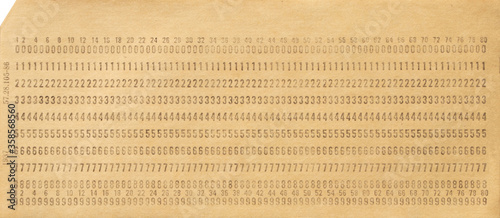 Paper punch card for storing information in the first electronic computers. One punch card. Data storage. Close up. Top view.