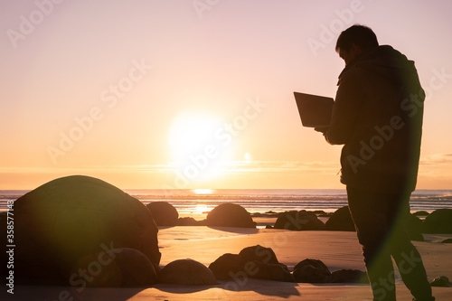 Asian man traveller visit at Moereki Boulder, New Zealand. Frelancer remotely worker. photo