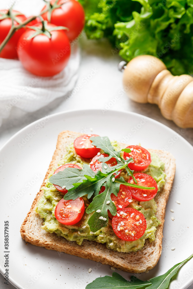 Avocado rye bread toast with cherry tomatoes and arugula. Avocado rye bread toast with cherry tomatoes and arugula.