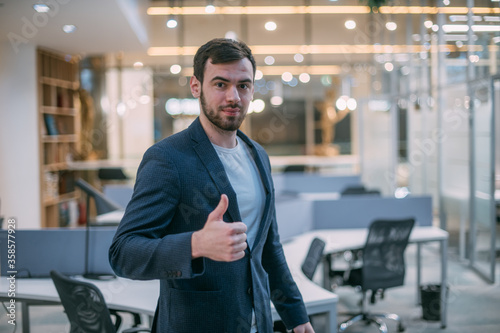 Portrait of a pleased young businessman in office