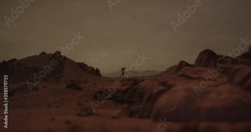 Lonely astronaut walking on a surface of a red rocky planet. Mars colonization concept. Dust effect added