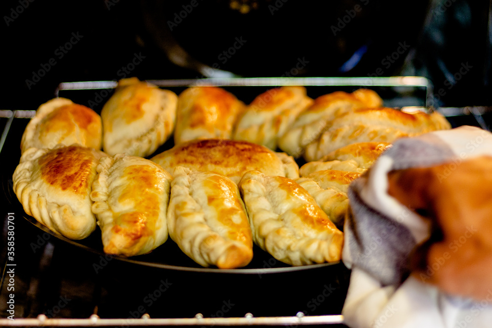 Latin man's hand preparing typical Argentine and South American pastries, 