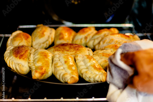 Latin man's hand preparing typical Argentine and South American pastries, "empanadas Argentinas". Concept of home cooking and housework.