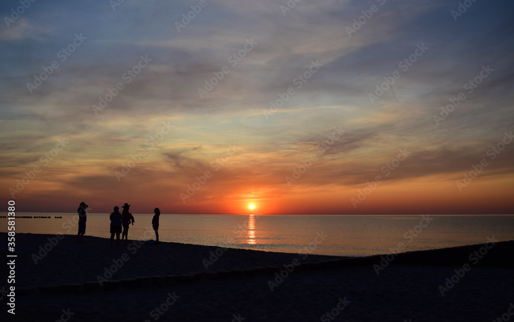 Ludzie na plaży podczas zachodu słońca