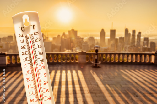 Thermometer in front of cars and traffic during heatwave