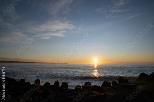 Beautiful view to rocky waterbreak in Oamaru, New Zealand with golden sunset.