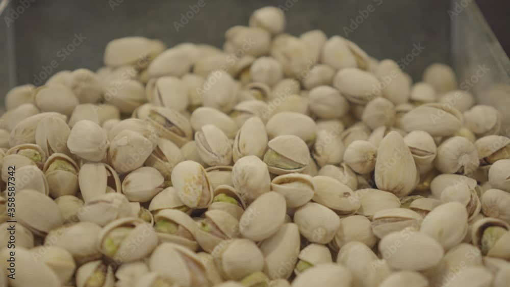 Close-up of pistachios lying on the shelf in grocery store. Bunch of fresh nuts for sale in supermarket. Healthy eating, vegetarianism, vegan food, culinary. S-log 2. Close-up of pistachios lying on the shelf in grocery store. Bunch of fresh nuts for sale in supermarket. Healthy eating, vegetarianism, vegan food, culinary. S-log 2.